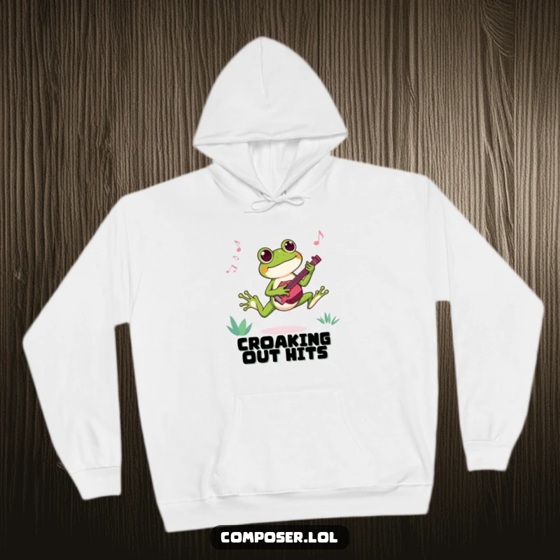 Funny hoodie featuring a joyful frog composer leaping with glee while composing a catchy new tune, full of vibrant energy.